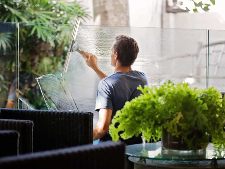 man performing professional window cleaning on interior office glass window