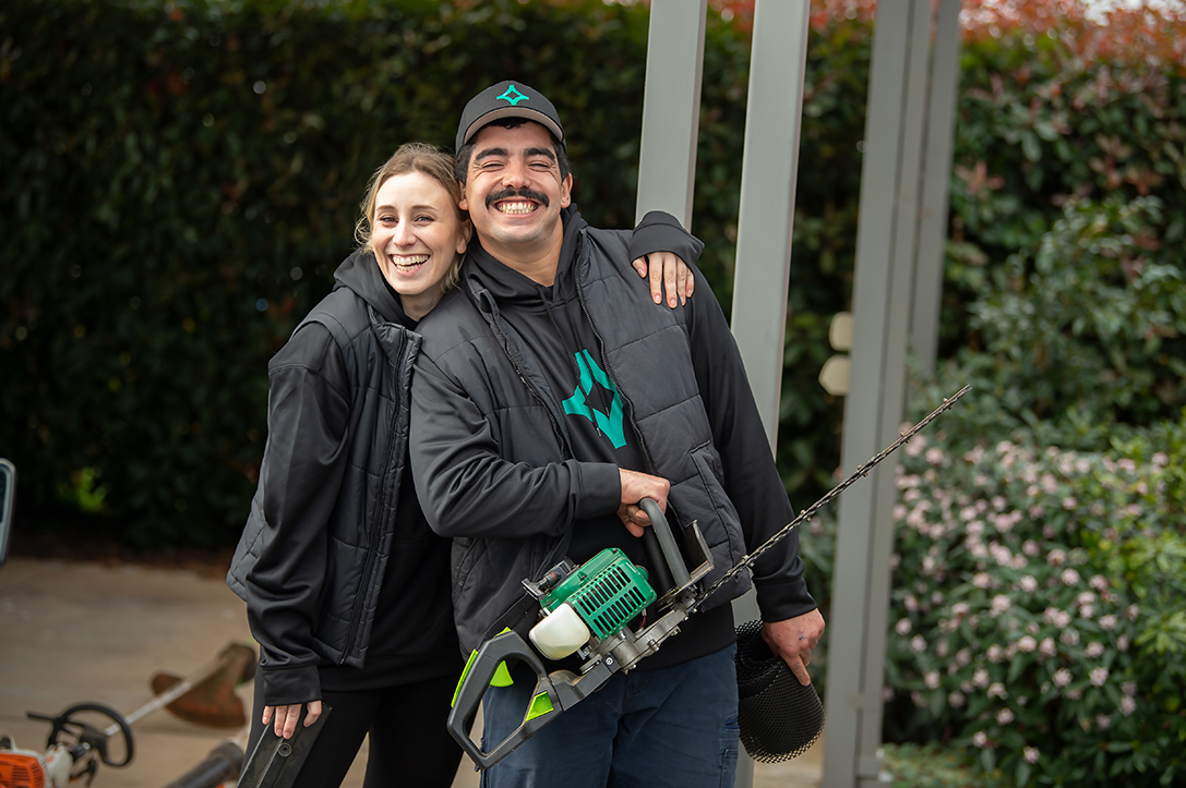 two cleanmade staff standing together and laughing and one has her arm around the shoulder of the man in front