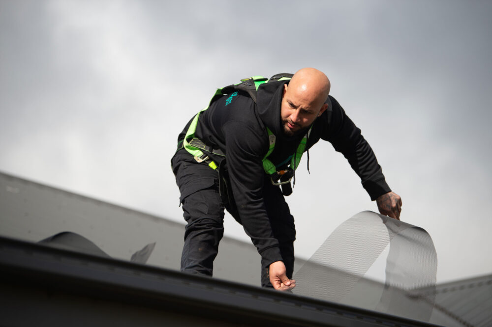 cleanmade technician on a roof installing mesh gutter guard in melbourne