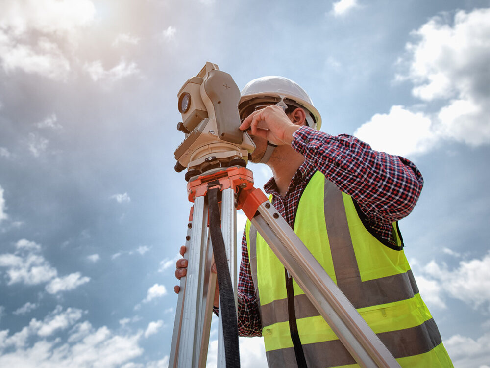 man using a surveying device