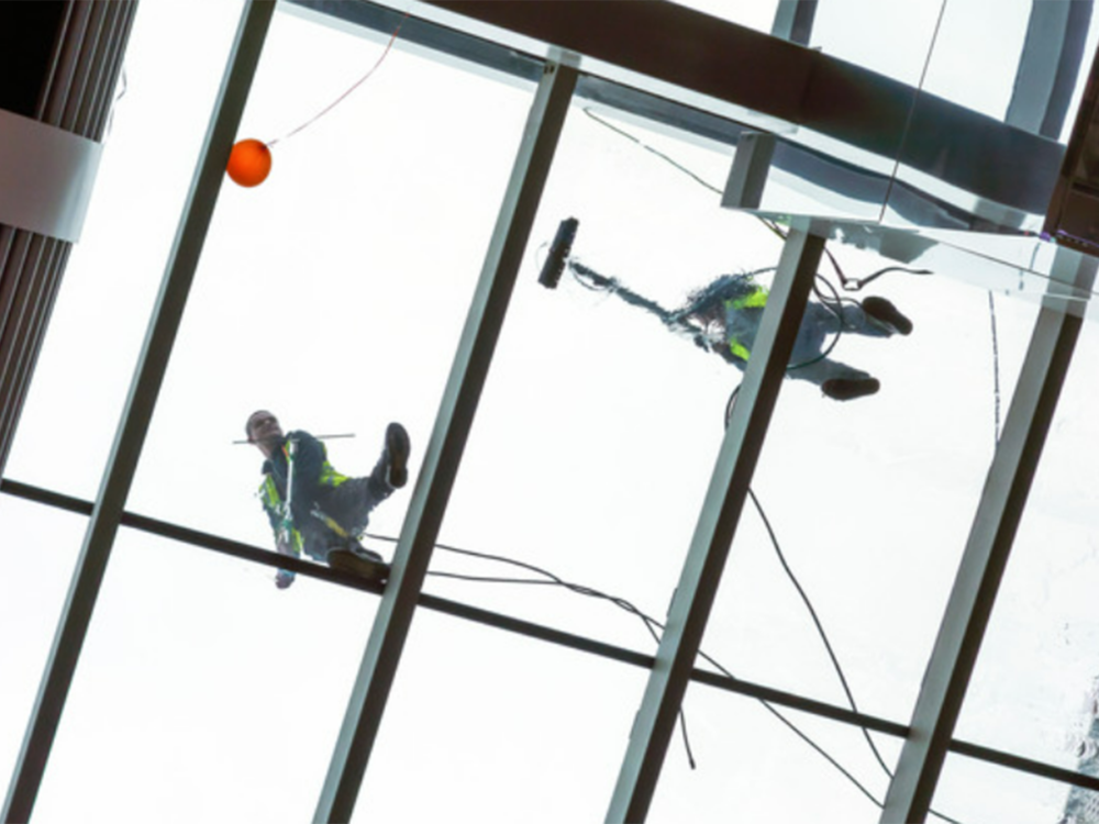 window cleaners looking down through glass roof